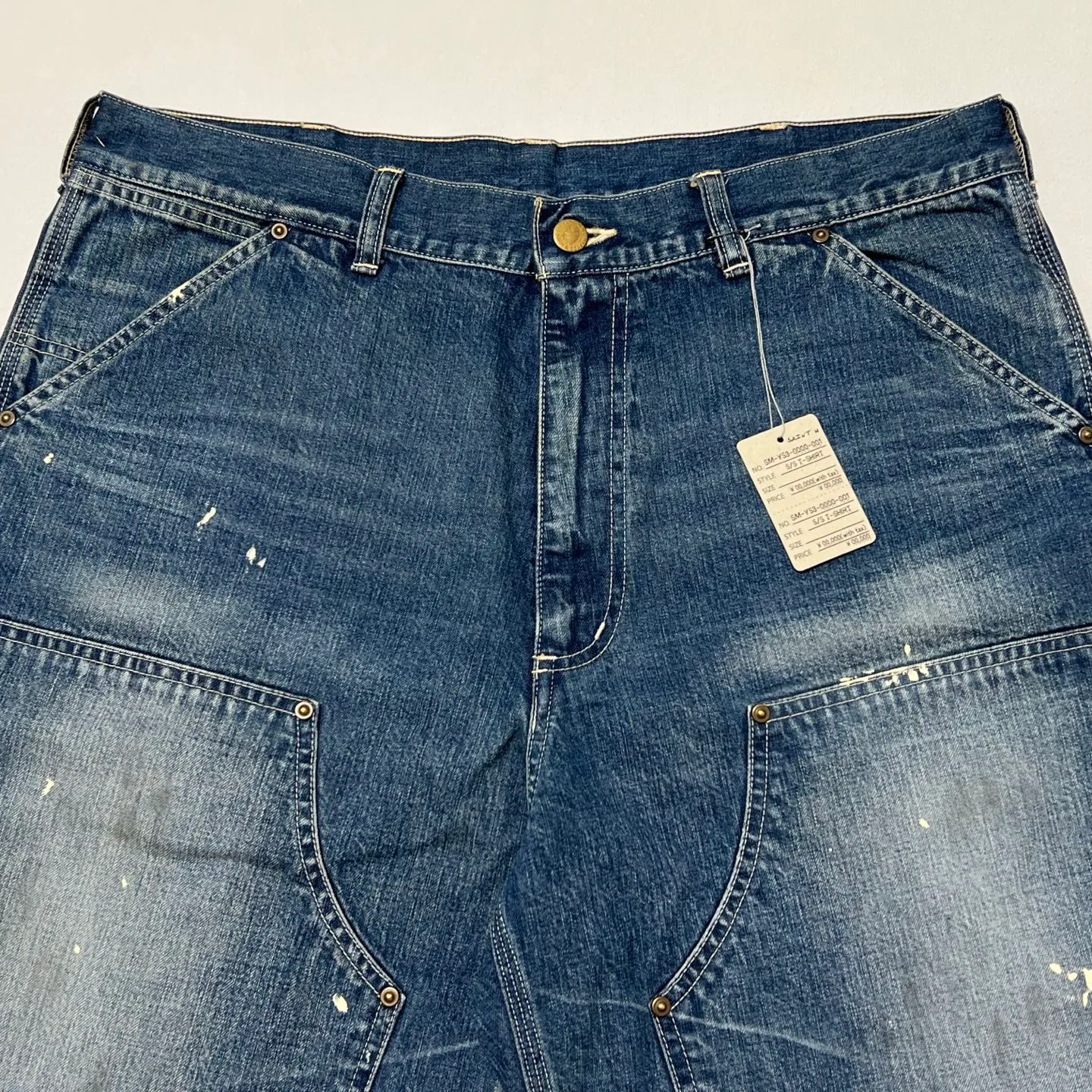 SAINT Mxxxxxx DOUBLE KNEE SHORTS/BLU Knee patches splashed with ink and water-splashed denim shorts. Denim blue S-XL. Custom-woven and dyed denim fabric with clear texture. Heavy-wash water-fading treatment to create local mottled fading/hole effects. Artificial distressing to simulate natural wearing marks. VINTAGE sense. Original consistent damage treatment. Hand-splashed ink and paint. Original consistent wash mark/pocket mark. Double knee patch. Rivet reinforcement. Improve functionality while enhancing design